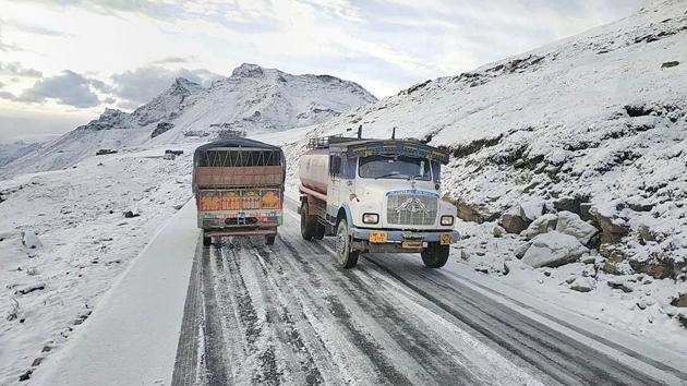 Vehicles ply on the snow-covered Manali-Leh road following fresh snowfall, near Rohtang Pass in Kullu, Himachal Pradesh. (PTI)