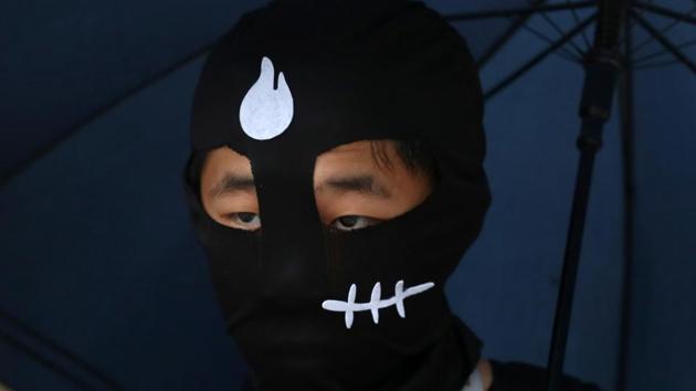 Detained early Saturday shortly after the ban took effect, the two were also charged with taking part in unlawful assembly. A conviction under the mask ban is punishable by up to a year in prison and a fine. They were both released on bail pending trial. (Athit Perawongmetha / REUTERS)