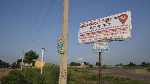 A sale and purchase for land signboard is seen in Jewar village. The Uttar Pradesh government has acquired land from farmers for the upcoming Noida International Airport in Jewar village, completing 75 per cent of required acquisition for the first phase of the project. The first phase of the airport would be spread over 1,334 hectare and is expected to be completed by 2023, according to officials. (Biplov Bhuyan/HT Photo)