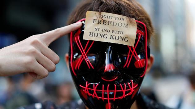 Two protesters were charged Monday with violating Hong Kong’s new ban on wearing masks at rallies. An 18-year-old student and a 38-year-old unemployed woman were the first to be prosecuted under the ban, which came into force Saturday under sweeping emergency powers aimed at quashing violence in the protests for more democratic freedoms. (Jorge Silva / REUTERS)