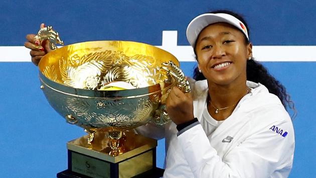 Naomi Osaka of Japan celebrates winning China Open with her trophy.(REUTERS)