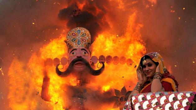 A lady dressed as Hindu goddess Sita puts her fingers in ears as an effigy of king Ravana goes up in flames during Dussehra festival in Jammu. (Nitin Kanotra / HT Photo)