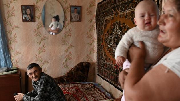 Dinar Izhmukhametov, 48, looks at his wife Elmira holding their granddaughter. Ravil’s parents are farmers and have livestock but they don’t want their son to stay in the village when he grows up. “Our eldest children live in the city and we’re happy about that,” said Dinar. The son says he has no interest in moving to the city, but that he realizes he will have no choice one day. (Alexey Malgavko / REUTERS)