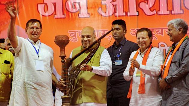 Union home minister Amit Shah being presented with a hookah during a rally at Meham town in Rohtak district on Wednesday.(Manoj Dhaka/HT)