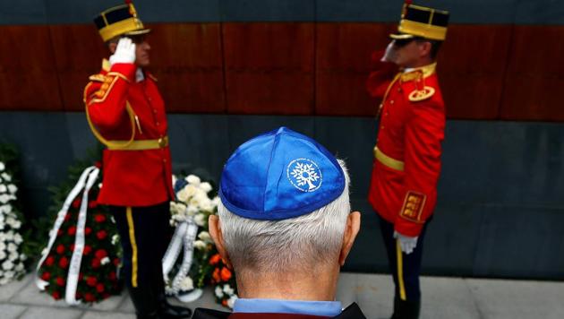 A member of Romania's Jewish community lays a wreath during ceremonies at a Holocaust memorial in Bucharest.(REUTERS)