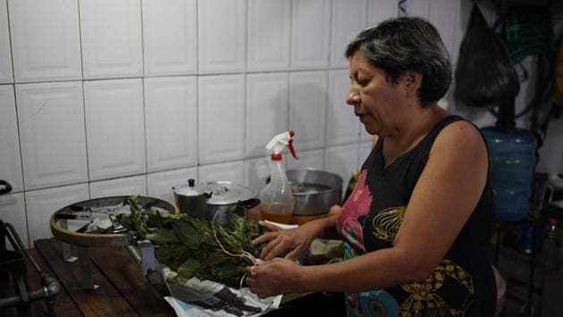Colombian Carmen Teresa, a Venezuelan resident, explains how she prepares a fig leaf tea as an alternative medicine for diabetes. (Yuri CORTEZ / AFP)