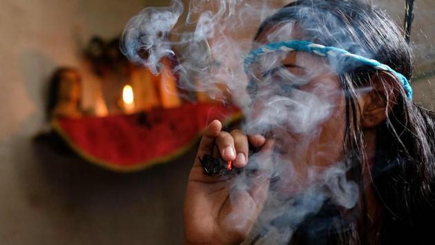 A person smokes at the clinic of Venezuelan spiritual healer “Guayanese Brother”. Rosales’ clinic is muggy with the smell of tobacco. A crucifix suspended from a chain around his neck, he practices a seeming mixture of smoke-blowing shamanism, plant-based medicine and mainstream religion. Posters hung near the entrance remind clients to arrive with a candle and tobacco and “Don’t forget that payment is in cash”. (Matias Delacroix / AFP)