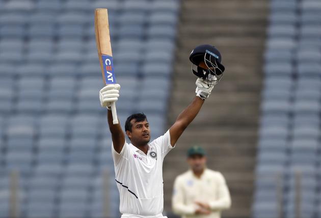 India's Mayank Agarwal raises his bat and helmet to celebrate scoring a century during the second cricket test match between India and South Africa in Pune. (AP)