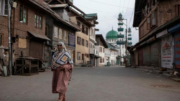 A woman walks through an empty street in Srinagar. (REUTERS File) A woman walks through an empty street in Srinagar. (REUTERS File)