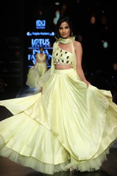 A model walks for Yogita Kadam showcasing her collection titled PrãnãyRã that draws inspiration from the magnificent opulence of Indian architecture from our spectacular monuments. The colour palette ranges from shades of Yellow Iris, Island Paradise and Living Coral. 