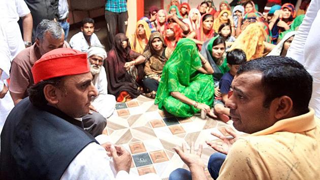 Samajwadi Party chief Akhilesh Yadav meets family members of Pushpendra Yadav in Jhansi on Wednesday.(ANI Photo)