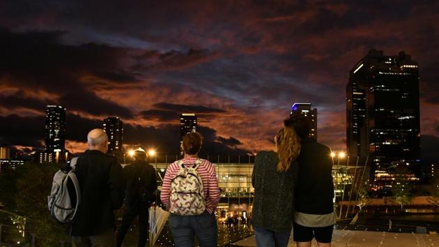 People look at clouds during sunset near Osaka Station, as typhoon 'Hagibis' approaches Japan, in Osaka, Japan. (Annegret Hilse / REUTERS)