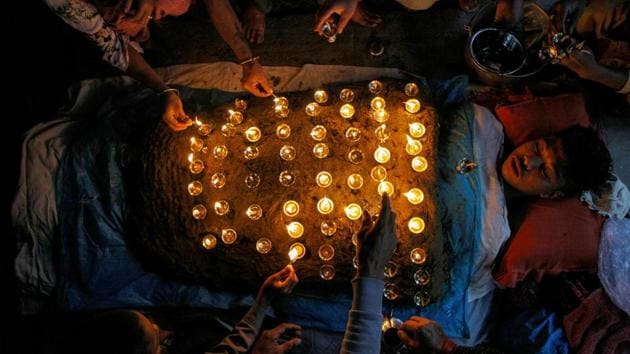 A devotee lies covered with oil lamps placed by other devotees while offering prayers as part of a ritual during "Dashain", a Hindu religious festival, in Bhaktapur, Nepal. (Monika Deupala / REUTERS)