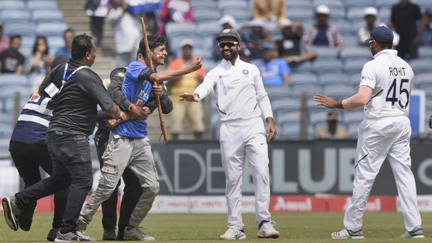 Security personnel attempt to atop a fan who ran towards the pitch to meet Indian batsman Rohit Sharma. (PTI) Security personnel attempt to atop a fan who ran towards the pitch to meet Indian batsman Rohit Sharma. (PTI)