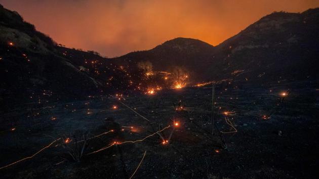 A time exposure shows embers from Saddleridge fire blown by the wind in the Porter Ranch section of Los Angeles, California. The fire broke out late October 10 and has scorched some 4,600 acres (1,816 hectares), and forced mandatory evacuation orders for 12,700 homes. (David Mcnew / AFP)