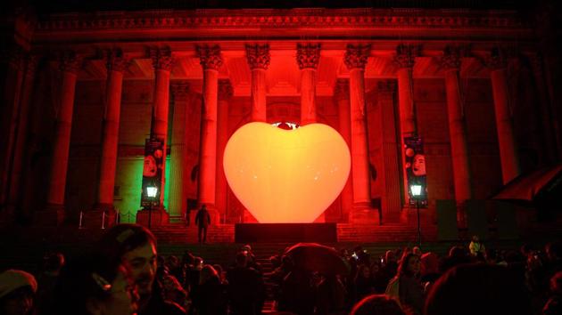 Members of the public admire the artwork 'With Love...' in front of Leeds Town Hall by French artist Franck Pelletier during the annual 'Light Night Leeds' festival of visual arts in the centre of Leeds, northern England. (Oli Scarff / AFP)