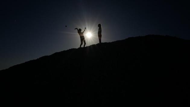 Children play with pebbles on the beach of the French riviera city of Nice. (Valery Hache / AFP)