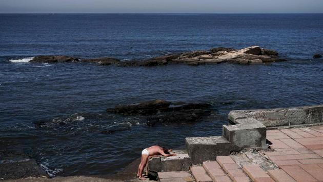 A man sunbathes at the Rambla of Montevideo, Uruguay. (Eitan Abramovich / AFP)