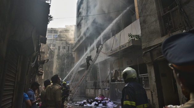 The rescue operation initiated by the fire brigade official is still underway as about 8-10 people are stranded on the fourth floor of the building.(HT PHOTO/ Satyabrata Tripathy)