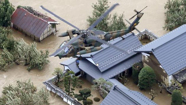 A resident is rescued by a Japan Self-Defence Force helicopter as the house is submerged in muddy waters after an embankment of the Chikuma River broke because of Typhoon Hagibis, in Nagano, central Japan. Rescue efforts for people stranded in flooded areas are in full force after a powerful typhoon dashed heavy rainfall and winds through a widespread area of Japan, including Tokyo. (Yohei Kanasashi / AP)