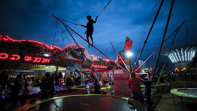 A child jumps on a trampoline at the fair. While younger people focus on the fairground rides and games, the elderly take advantage of the markets, stocking up on winter supplies of fruits, vegetables and other household items available at lower prices than in Romania’s mainstream shops. (Vadim Ghirda / AP)