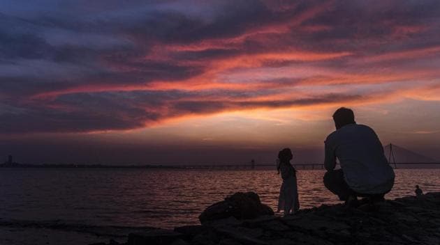 A couple takes pictures during dusk, at Dadar Chowpatty, in Mumbai, Maharashtra. (Pratik Chorge / HT Photo)