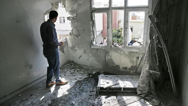 A person inspects the damage on a building hit by a mortar fired from inside Syria, in Akcakale, Sanliurfa province, southeastern Turkey, Sunday, Oct. 13, 2019. (AP photo) A person inspects the damage on a building hit by a mortar fired from inside Syria, in Akcakale, Sanliurfa province, southeastern Turkey, Sunday, Oct. 13, 2019. (AP photo)