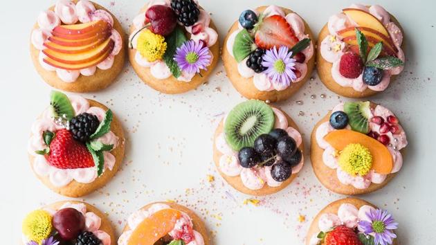 Sugar-glazed donuts decorated with fresh fruit assortments. (unsplash)