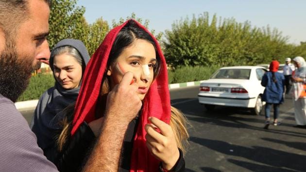 An Iranian woman gets her national flag painted on her face as she arrives at the Azadi stadium ahead of the match. In what many considered a victory in a decades-long fight by women in Iran to attend sporting events, they wrapped themselves in the country’s vibrant red, green and white colors and watched with excitement as Iran thrashed Cambodia 14-0 in the qualifier at Azadi, or Freedom, Stadium. (Atta Kenare / AFP) An Iranian woman gets her national flag painted on her face as she arrives at the Azadi stadium ahead of the match. In what many considered a victory in a decades-long fight by women in Iran to attend sporting events, they wrapped themselves in the country’s vibrant red, green and white colors and watched with excitement as Iran thrashed Cambodia 14-0 in the qualifier at Azadi, or Freedom, Stadium. (Atta Kenare / AFP)