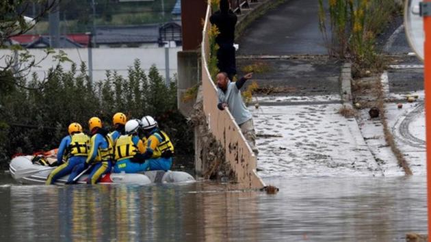 A man talks with rescue workers searching a flooded area in the aftermath of Typhoon Hagibis.(REUTERS Photo)