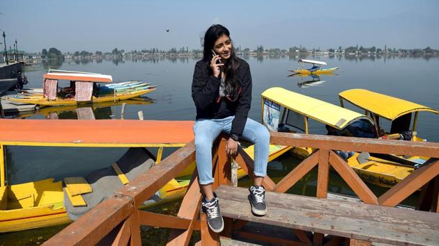 A tourist talking on her mobile phone as the Postpaid mobile services have been restored by Government, at the banks of Dal Lake in Srinagar on Monday. (ANI Photo)(ANI) A tourist talking on her mobile phone as the Postpaid mobile services have been restored by Government, at the banks of Dal Lake in Srinagar on Monday. (ANI Photo)(ANI)
