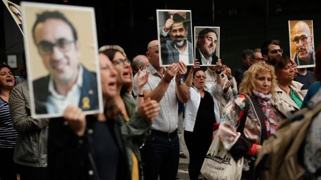 People hold placards depicting pictures of jailed Catalan separatist leaders. The longest prison term - 13 years - was imposed on the Catalan government’s former deputy leader, Oriol Junqueras. The court convicted him and eight other leaders on charges of sedition and four of them of misuse of public funds. Three others were found guilty of disobedience and not sentenced to prison. All defendants were acquitted of the gravest charge, rebellion. (Pau Barrena / AFP)