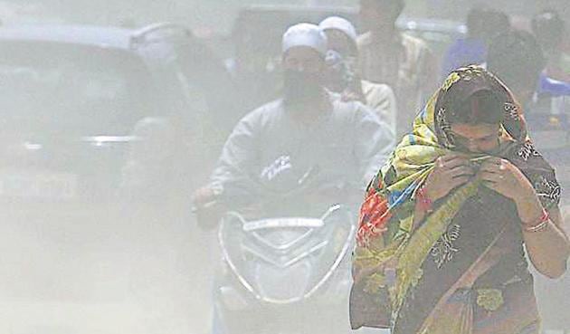 People try to cover their faces as dust blows due to traffic movement in the area around Trilokpuri road which is falling into disrepair and adding to air pollution, in New Delhi(Raj K Raj/HT PHOTO)