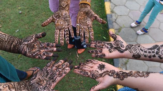 Indian women have their hands decorated with henna mehandi on the eve of Karwa Chauth at Hanuman Temple, Connaught Place in New Delhi. (Sanchit Khanna/HT PHOTO)