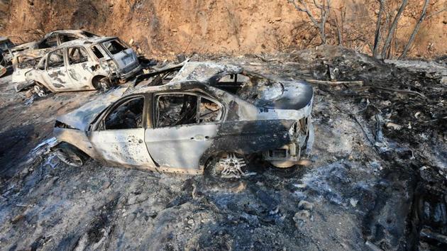 Vehicles lie on the side of a road, after they were burnt by fires near the town of Damour. The fires have left charred trees and burned-out cars and have overpowered Lebanon’s fire brigades, prompting appeals to neighhouring states to send aircraft to bolster efforts. (AFP)