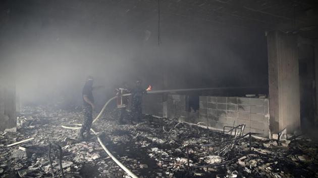 Lebanese firemen extinguish a fire inside a building that was burned in a wildfire overnight. A civil defence official said 104 fires had broken out over the past 24 hours, and that residents had been evacuated from homes and buildings to minimise the toll. (Hassan Ammar / AP)
