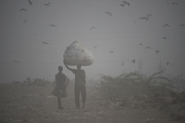 Ragpickers walk through a cloud of dust at Ghazipur dumping yard. The Haryana Pollution Control Board noted that when compared to 2018, cases of crop residue burning had gone down “marginally”, despite the harvest beginning early this year. In 2018, between September 25 and October 16, at last 1,250 cases of stubble burning had been reported. This year, only 1,217 cases were reported during the same period. (Burhaan Kinu / HT Photo)