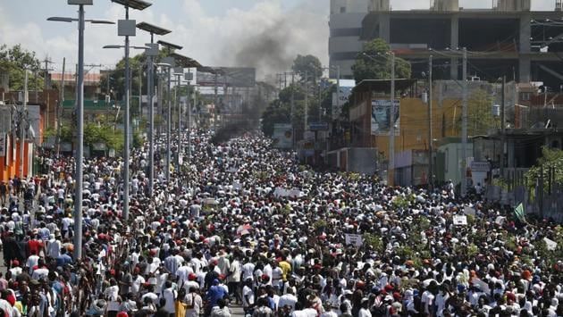 Protesters led by the art community demanding the resignation of Haitian President Jovenel Moise as they march through Port-au-Prince on October 13. Sixty percent of the people in a country of nearly 11 million make less than $2 a day and 25% less than $1 a day. “Not our president” and “We want a different Haiti,” read signs in the protest. (Rebecca Blackwell / AP)