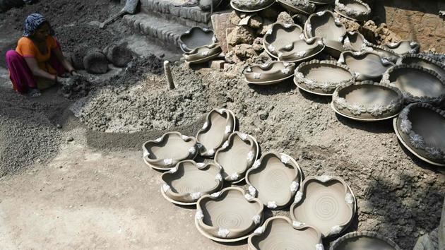A woman prepares pots made of clay. “People come here from all over India around festivals because the (clay) oil lamps here are special,” market vendor Kumar Prajapati explained. He added: “Whatever you need is available here... which you won’t find anywhere else.” (Money Sharma / AFP)