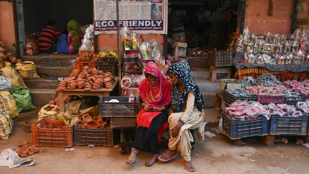 Women use a mobile phone as they sit outside their shop displaying items made of clay, at Kumhar Gram. At a market in the village, Sushil Panwar and his wife Pratibha were buying decorations for the festivals. “I have been coming here for a decade now. We take all clay decoration items for our home, like flower pots and earthen lamps from here,” Panwar said. (Money Sharma / AFP)