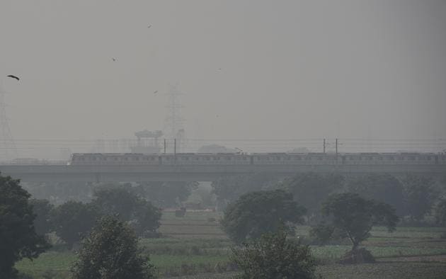 A view of the moving metro as smog engulfs the Delhi skyline.(Mohd Zakir/HT PHOTO)