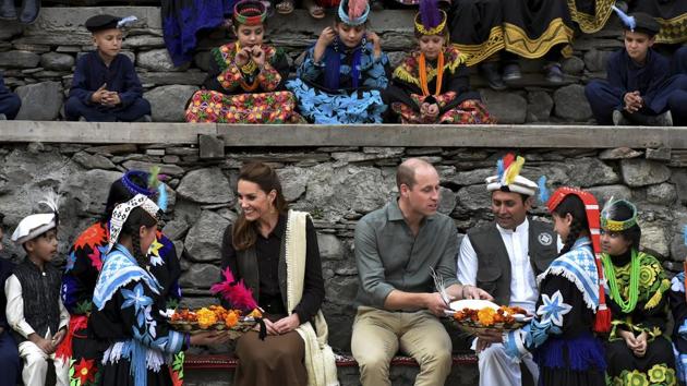Members of Kalash community greet Britain’s Prince William, (C), and his wife Catherine with presents and traditional caps during their visit to Bumburate Valley, an area of Pakistan’s northern Chitral district. (AP)