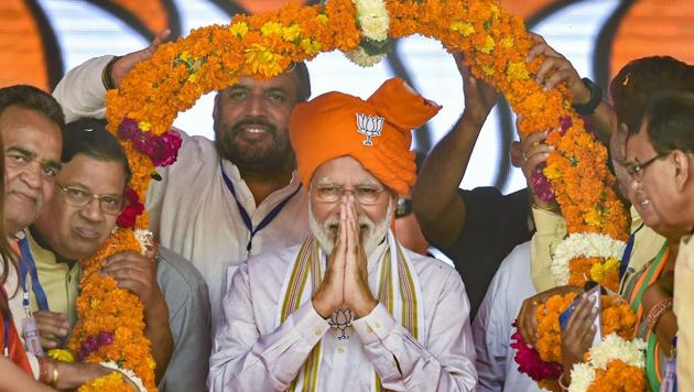Prime Minister Narendra Modi being garlanded during an election campaign rally ahead of Assembly polls in Hisar district of Haryana on Friday.(Photo: PTI)