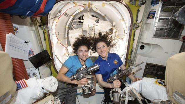 NASA astronauts Jessica Meir (L) and Christina Koch pose for a photo in the International Space Station on Friday, ahead of their spacewalk to replace a broken battery charger. Koch and Meir made “HERstory,” as NASA is calling it, with the first all-female spacewalk. (NASA / AP)