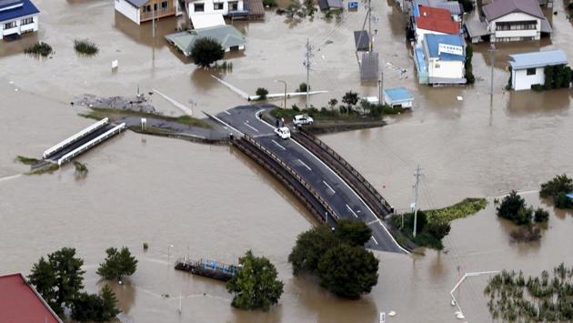 Cars are stranded on a road as the city is submerged in muddy waters after an embankment of the Chikuma River broke, in Nagano, central Japan. Rescue efforts for people stranded in flooded areas remained in full force after a powerful typhoon dashed heavy rainfall and winds through a widespread area of Japan, including Tokyo. (Yohei Kanasashi / Kyodo News via AP)