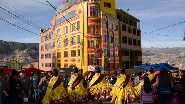 Members of a morenada fraternity perform in front of a colourful events salon, locally known as “cholet”, during the Gran Poder Fiesta. One recent issue that has hurt Morales has been forest fires that raged though the farm-belt region of Santa Cruz. Morales closed his election campaign out there and violent clashes broke out between protesters and police. (Manuel Seoane / REUTERS)