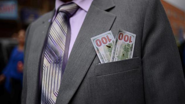 Miniature dollar bills are displayed inside a jacket pocket to symbolise a petition of wealth to the gods during preste celebrations.”This government hits our growth with very unequal tax policies,” Segales said , who though disillusioned by the government said it had started well when Morales first came to power. (Manuel Seoane / REUTERS)