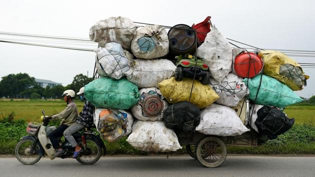 Waste collectors transport plastic scrap for recycling in the suburbs of Hanoi, Vietnam. (Nhac Nguyen / AFP)