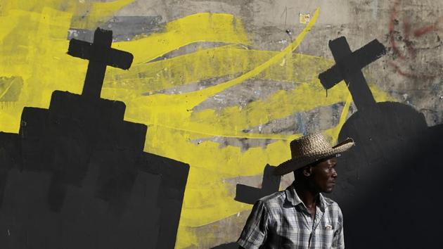 A man walks past a mural being painted by students from the National School of the Arts to express solidarity with those killed during a month of protests demanding the president’s resignation in Port-au-Prince, Haiti. (Rebecca Blackwell / AP)