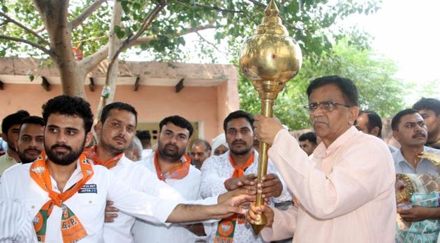 Haryana agriculture minister Om Prakash Dhankar holding a mace at a village in Badli constituency in Jhajjar district (HT Photo) Haryana agriculture minister Om Prakash Dhankar holding a mace at a village in Badli constituency in Jhajjar district (HT Photo)